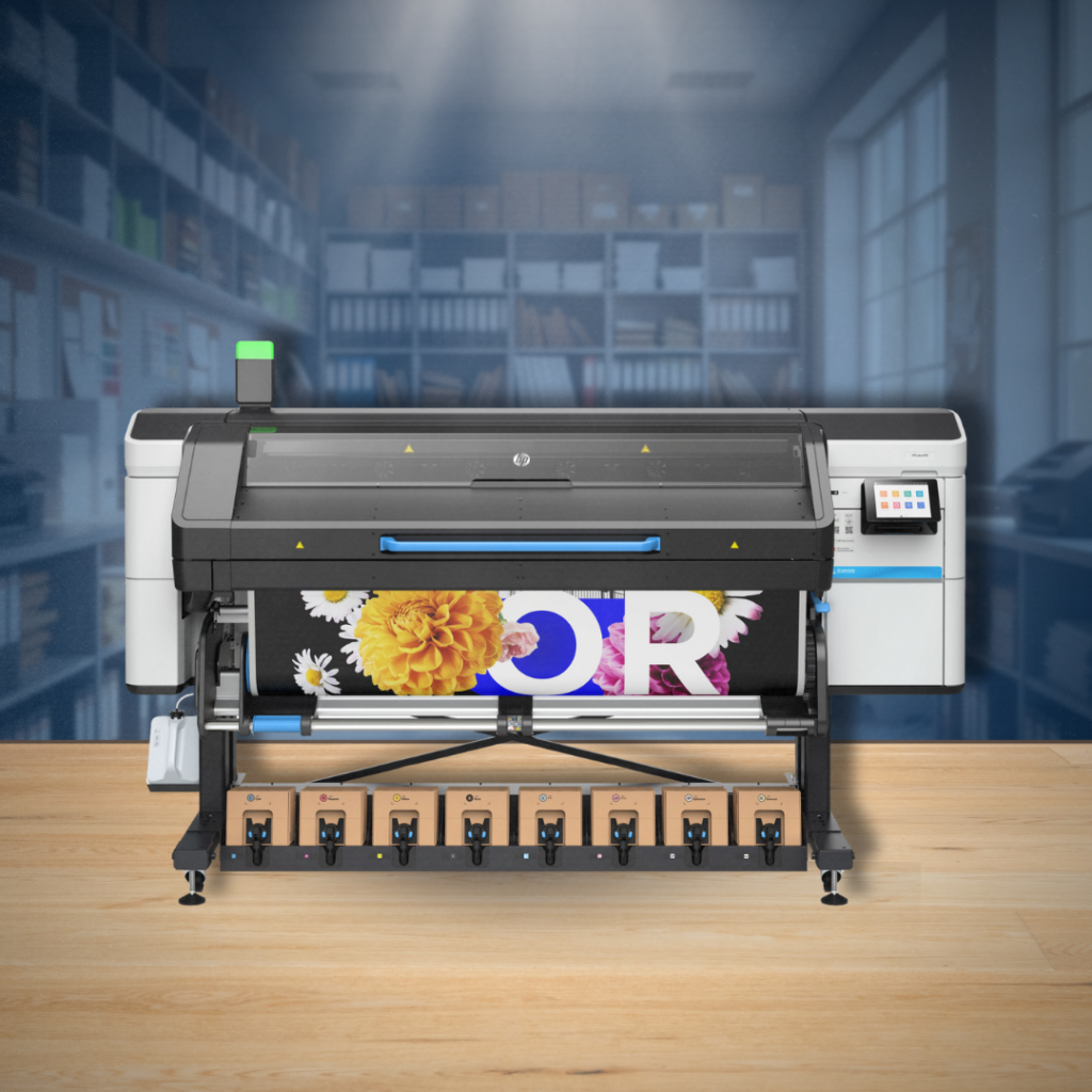 A large-format industrial printer is shown mid-print, producing a vibrant graphic with floral elements and bold text within a professional workshop or studio environment.