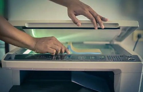 A man doing a scanning on his document and processing its imaging formats